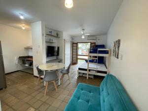 a living room with a couch and a table and chairs at Pé na Areia na Praia das Toninhas - Villagio 24 Porto Feliz in Ubatuba