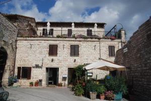 un edificio de ladrillo con balcón en la parte superior en Albergo La Rocca, en Asís