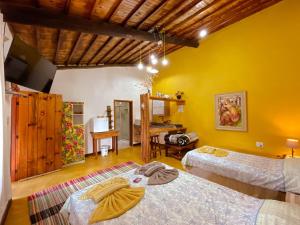 a room with two beds and a desk in it at Chalés Lá na Roça in Gonçalves