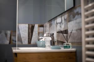 a bathroom sink with a faucet and a mirror at La Casa del Postino in Farigliano +46 photos