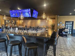 a bar with black stools in a restaurant at HomeTowne Studios by Red Roof Painted Post in Painted Post