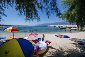 a beach with umbrellas and people in the water at MY DALMATIA - Beach Apartment Neno in Ražanac