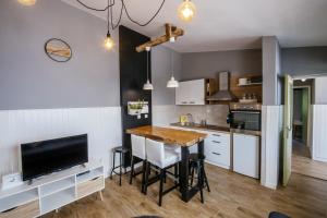a kitchen with a table and a television in a room at MY DALMATIA - Beach Apartment Neno in Ražanac