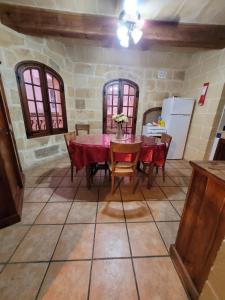 a kitchen with a table and chairs and a refrigerator at UNDER NEW MANAGEMENT! Sant Antnin Luxurious Farmhouse Villa With Pool Sannat Near Victoria Gozo Family Friends Couples Views Balcony Roof Terrace Romantic Getaway in Munxar