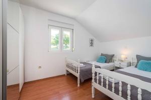 a white bedroom with two beds and a window at MY DALMATIA - Holiday home Agro Casa with private heated pool in Skradin +43 photos