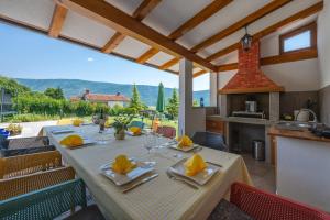 a dining room with a table and chairs and a kitchen at Activity and familiy Villa Milena with heated pool in Kršan