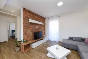 a living room with a couch and a brick wall at MY DALMATIA - Sea view villa Possedaria with amazing roof terrace in Posedarje