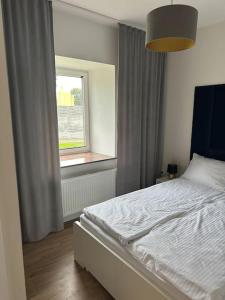 a bedroom with a white bed and a window at Apartament Kryształ in Piechowice +4 photos