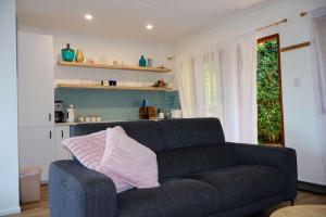 a living room with a couch and a window at Bluebell Cottage in Beechmont