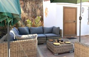 ein blaues Sofa, zwei Korbsessel und ein Regenschirm in der Unterkunft 5 Bedroom Cozy Home In Arenas in Arenas