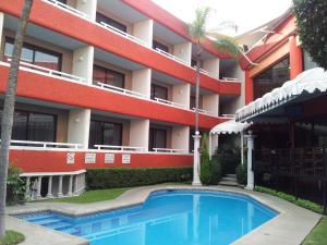 ein Hotel mit einem Schwimmbad vor einem Gebäude in der Unterkunft Hotel Real del Sol in Cuernavaca