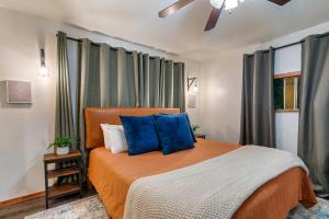 a bedroom with an orange bed with blue pillows at Cozy Mountain Cabin, Sleeps 8, Mini Golf, Hot Tub, Coffee Bar! in Sevierville