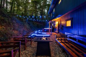 a row of benches next to a building with lights at Cozy Mountain Cabin, Sleeps 8, Mini Golf, Hot Tub, Coffee Bar! in Sevierville +7 photos