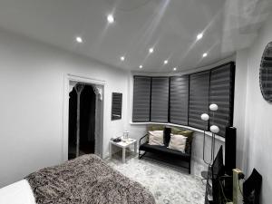 a bedroom with a bed and a chair and a window at Modern One Bedroom Flat in Twickenham for Business Travelers in Hanworth