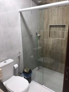 a bathroom with a glass shower with a toilet at Suítes Central in Maragogi +6 photos