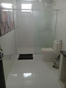 Un baño blanco con inodoro y lavabo. en Residencial Roseleia, en Penha