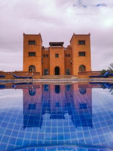 un edificio con una piscina di fronte di Hotel Kasbah Riad Amnir a Mhamid