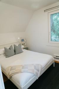 a bedroom with a bed with two pillows and a window at Beecomb House Modern Water View House in Charlottetown