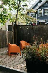 two orange chairs sitting on a wooden deck at Beecomb House Modern Water View House in Charlottetown