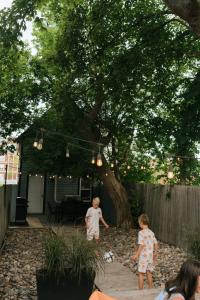two children playing in a yard under a tree at Beecomb House Modern Water View House in Charlottetown