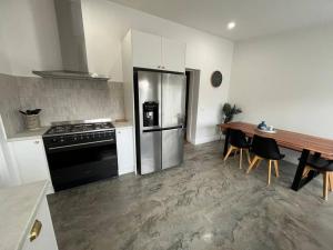 a kitchen with a stainless steel refrigerator and a table at Baxter Cottage in Bendigo