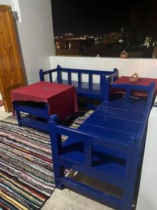 a blue bench with a red table on a rug at Shamandy house same same but different in Jazīrat Aswān