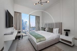 a bedroom with a bed and a desk and a window at Prime Burj Khalifa&Fountain Views 2 Bdr Apartment in Dubai