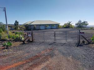 a gate in front of a house with a house at Ocean View Paradise! in Hawaiian Ocean View