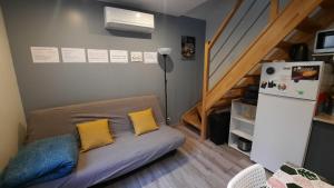 a small room with a couch and a refrigerator at Maison avec Parking, proche Tours in Vouvray