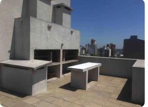 a bench and a table on a rooftop at Ballester city in Villa Ballester