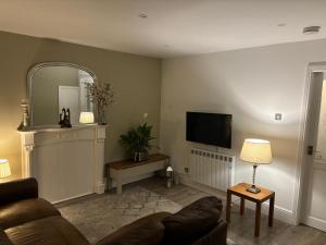 a living room with a couch and a flat screen tv at Williamson House Lancaster in Lancaster
