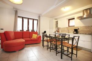 a living room with a red couch and a table at Casa Boni Ferias in Colico +8 photos