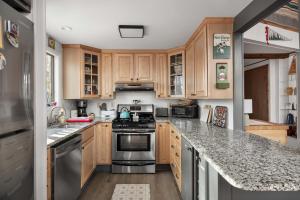 a kitchen with wooden cabinets and stainless steel appliances at Mountainside w Fireplace, Fire Pit, Deck, & WiFi in Smith Crossroads
