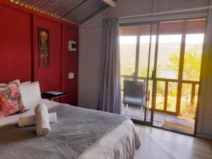 a bedroom with a bed and a large window at Entendeni Lodge SelfCatering in Inanda