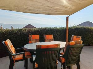 a table and chairs under an umbrella on a patio at Wellness Park Apartman in Dunaszentmiklós
