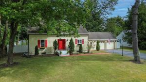 a house with a red door and a yard at Charming Home near I-87 JCT in Queensbury