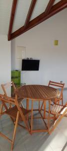 einen Holztisch und Stühle in einem Zimmer mit Klavier in der Unterkunft HAUT DE VILLA VU SUR LA MONTAGNE. in Saint-Louis