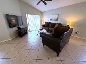 a living room with a couch and a flat screen tv at Southern Dunes - Golf Course Views Villa in Haines City