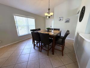 a dining room with a wooden table and black chairs at Southern Dunes - Golf Course Views Villa in Haines City