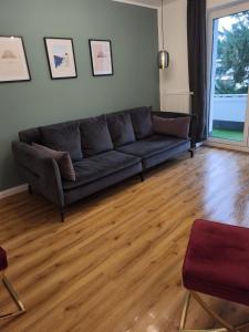 City-Krefeld Luxus 3 Zimmer Apartment mit Balkon في كريفيلد: غرفة معيشة مع أريكة وأرضية خشبية