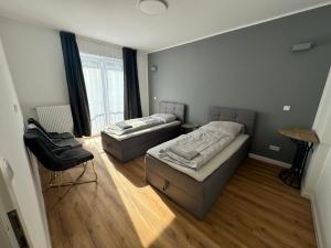 City-Krefeld Luxus 3 Zimmer Apartment mit Balkon في كريفيلد: غرفه سريرين وكرسي فيها