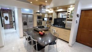 a kitchen with a table with chairs and a stove at Amplio y Hermoso Apartamento in Maracay