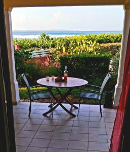 a table and chairs on a patio with a view of the ocean at Blue Side in Le Moule