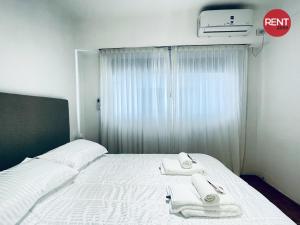a bedroom with a bed with two towels on it at Rent Aguero in Buenos Aires