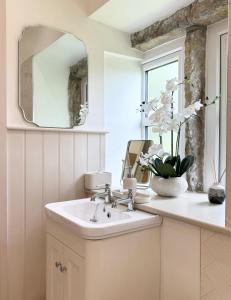 a bathroom with a sink and a mirror at Bents Holiday Cottage, Views & Parking for two cars in Oxenhope +45 photos