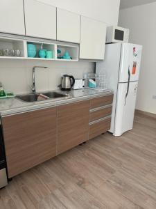 a kitchen with a sink and a refrigerator at Casa Silva in Las Grutas +6 photos