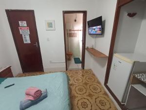 a small room with a bed and a television at Refúgio Piratininga 202 in Niterói