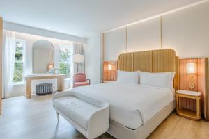 a bedroom with a large white bed and a chair at Hotel Bardo Savannah in Savannah