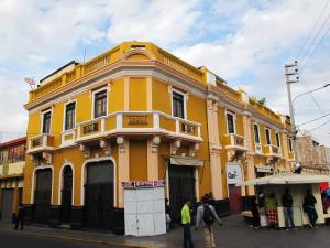 żółty budynek na rogu ulicy w obiekcie Park Hostel w mieście Arequipa