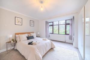a white bedroom with a large bed and a window at Over Lane in Almondsbury